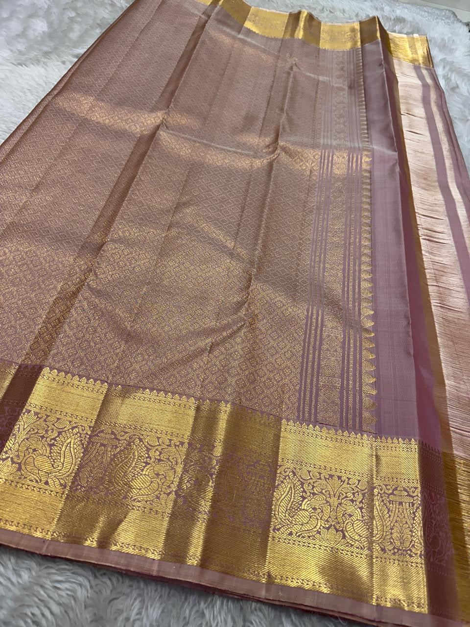 Lilac Mayil – Pure Kanchipuram Silk Saree
Ash-Lilac Body with Zari Kattam Checks & Buttas
Broad Antique-Gold Peacock Zari Borders
Grand zari Pallu
Silk Mark Certified | Fall & Pico Done | Blouse Stitching Available | ships in two weeks Free