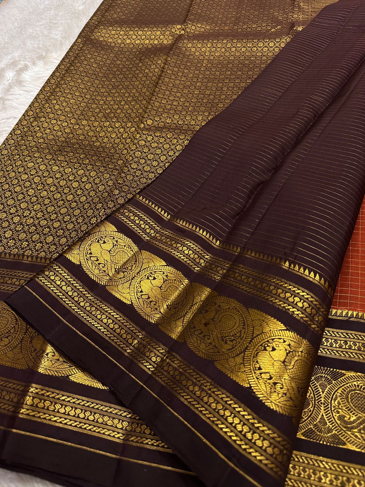 Diya Rust Orange – Pure Silk Kanchipuram
Rust-orange kattam checks with coin buttas ✨
Coffee-brown korvai borders with grand Annam medallions 🪔
Rich coffee-brown brocade pallu with zari stripe weave 🌿
Silk Mark Certified • Ships in Two Weeks • Free Ship