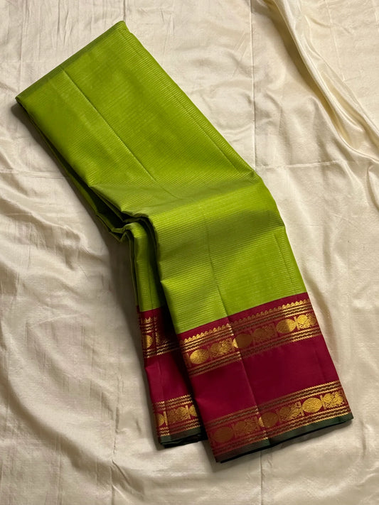 Maavilai Arakku Chakram — Korvai Kanchipuram Pure Silk
Parrot-green vaira-oosi body with soft pin-stripe sheen
Contrast arakku/rani border with gold chakram medallions & temple motifs
Arakku pallu with all-over coin-jaal; contrast blouse included