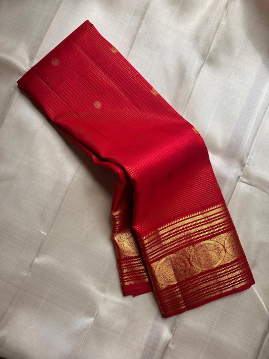 Vermilion Podi Kattam 🌺 Pure Silk Kanchipuram Saree
All-over zari pinstripes & mini podi kattam checks ✨
Broad antique-gold borders with chakram medallions 🪙
Silk Mark Certified ✅ | F