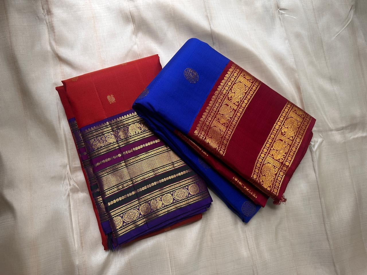 Cobalt Blue Ruby — Pure Silk Kanchipuram Saree (Mayil Edition)
Royal Cobalt-Blue Body with Gold Mandala Buttas & Ruby-Red Peacock Zari Border ✨
Silk Mark Certified • Free USA Shipping • ships in 2 weeks