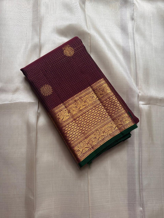 Madhuvanam — Pure Silk Kanchipuram Saree
Brownish-plum body with gold buttas & kattam checks ✨
Antique-gold korvai borders & grand magenta zari pallu 🌸
Silk Mark Certified • Ships in Two Weeks • Free Shipping within USA
