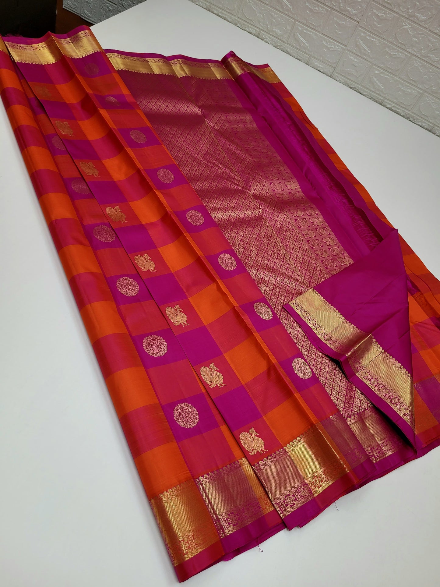 Laya – Paalum Pazhamum Checked Kanchipuram Silk Saree
Bathed in the serene hues of pink, magenta, and orange, Laya weaves tradition and vibrance through its classic kattam pattern, adorned with delicate Mayil Chakram buttas .