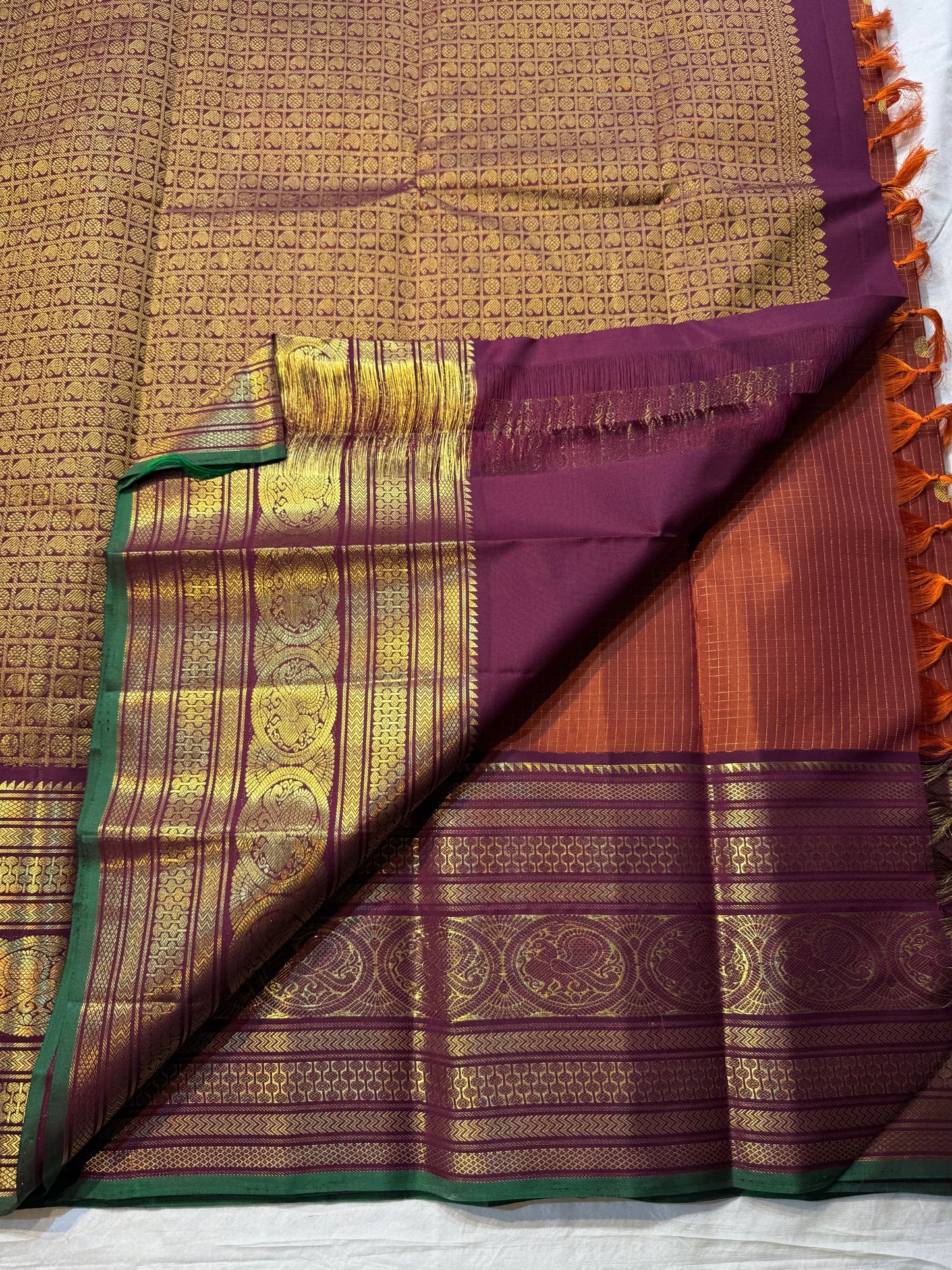 Rust Orange Pakshi Kattam – Pure Korvai Kanchipuram Silk Saree
Rust-orange micro-checked body with zari rosette & mango buttas
Plum korvai border with pakshi medallions & emerald selvedge; ships in two w
Silk Mark Certified | blouse Stitching available