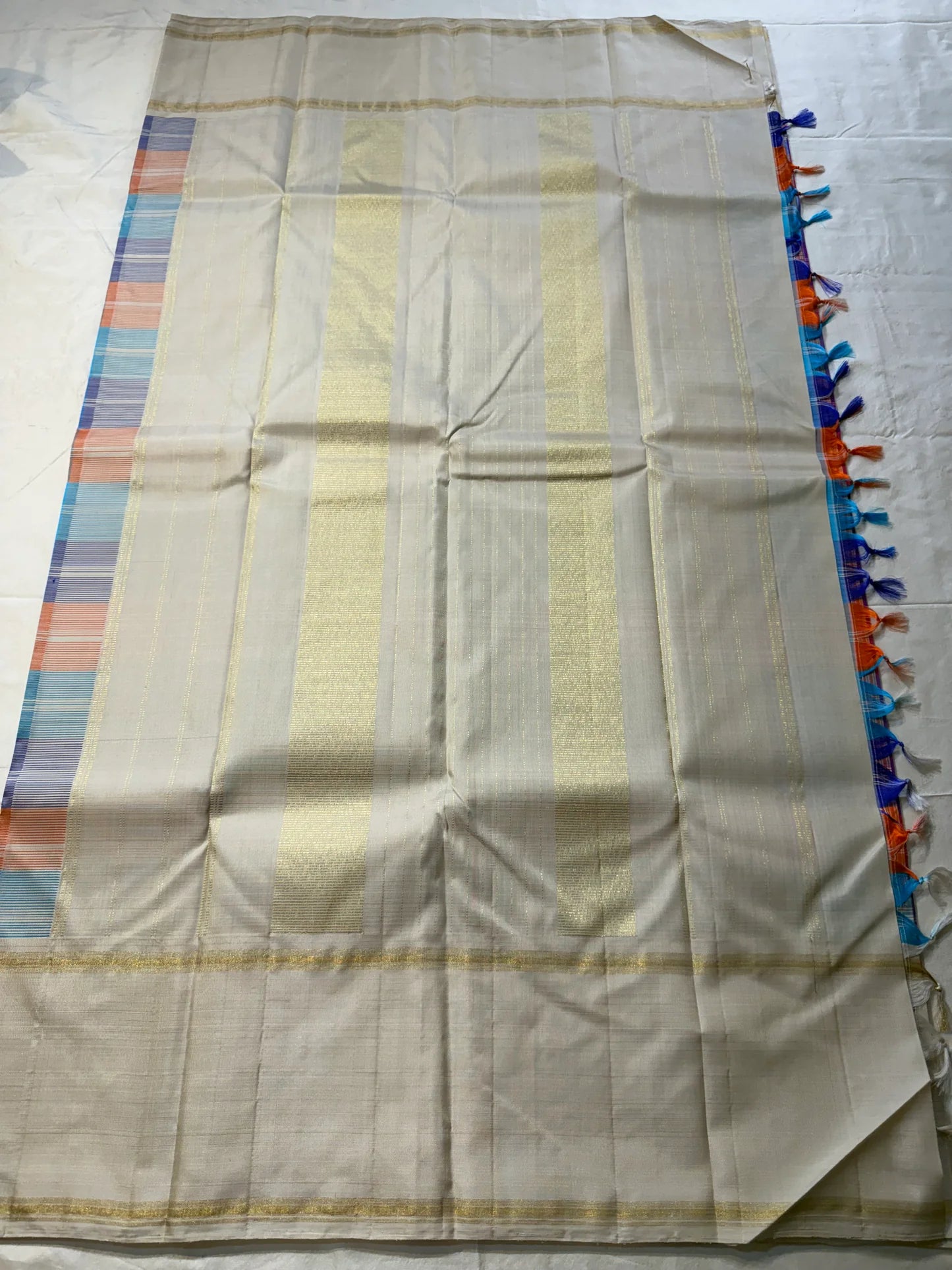 Venpattu Kattam Thazampoo Reku – ivory/venpattu borders with multicolor kattam (checks) body
Pure Kanchipuram silk • rani pink, tangerine, purple, sky blue & steel grey checks with thazampoo reku edging
Ivory pallu with gold tissue stripes & multicolor