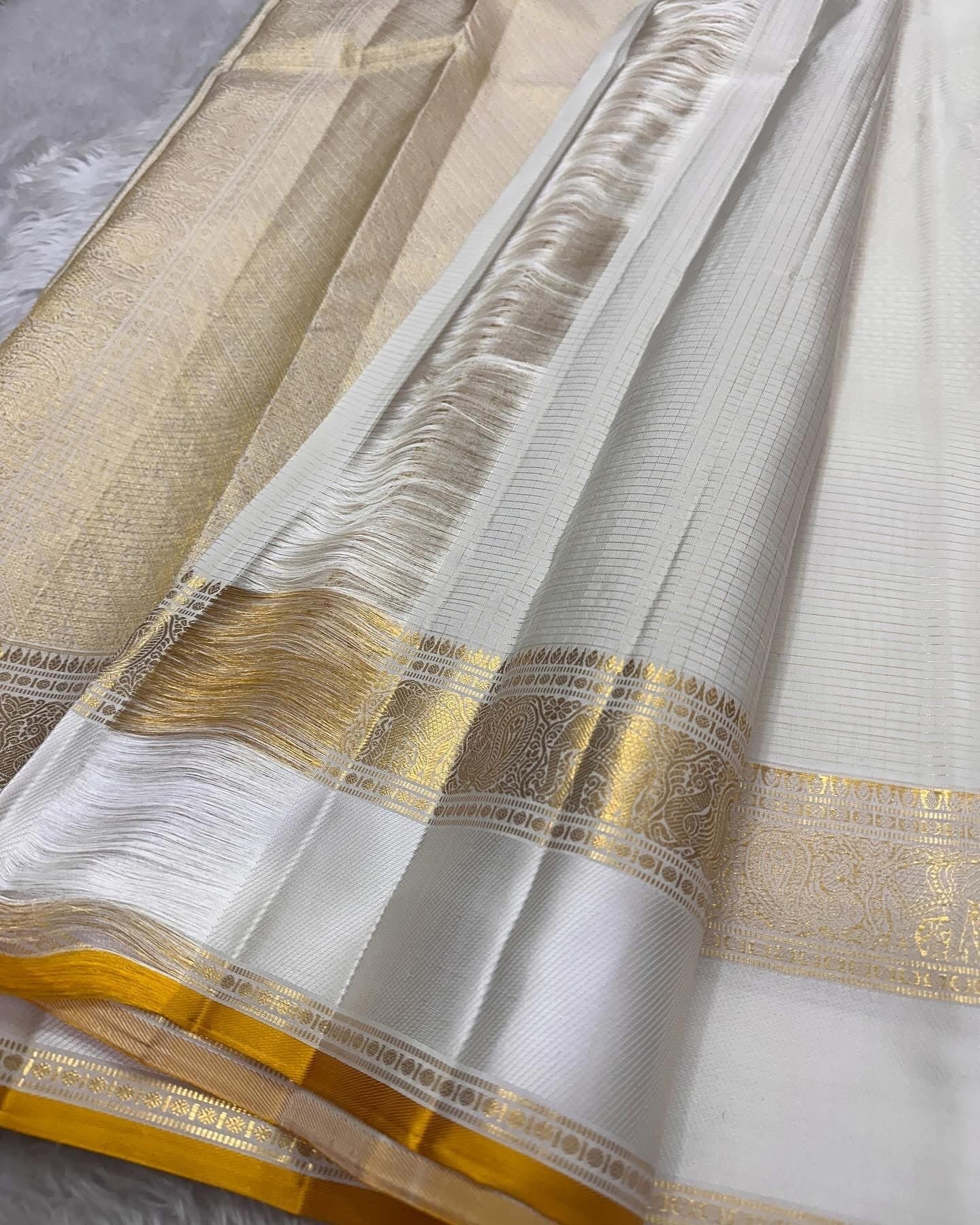 Kiran ivory whiteb oosi kattam ✨ – ivory and gold Kanchipuram Pure Silk Saree
Korvai Gold Zari Border with Elephant & Floral Motifs
Body Woven in Zari Kattam Checks with Scattered Gold Buttas
Grand Zari Brocade Pallu | Silk Mark Certified |