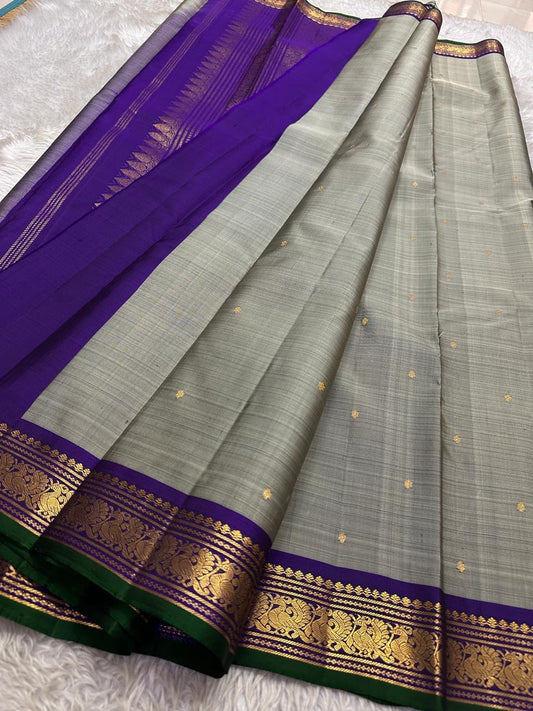 Dove Gray Mayuri — Pure Kanchipuram Silk Saree ✨
Soft dove-gray body with gold coin buttas, violet borders & emerald selvedge 💜
Silk Mark Certified ✅ | ships in two weeks