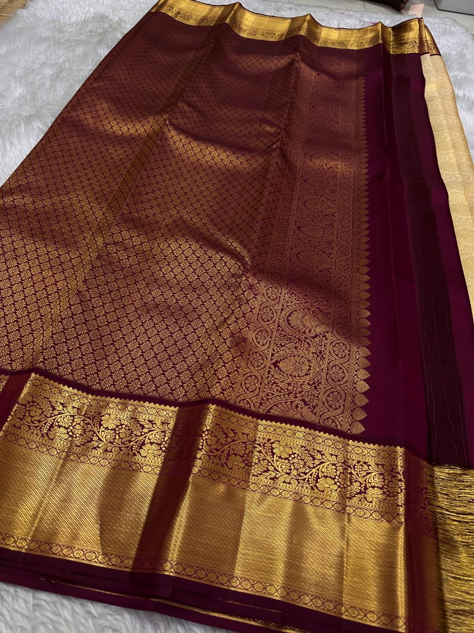 Ragini – Ivory & Gold Kanchipuram Pure Silk Saree with Floral Jaal & Maroon Baavanji Border
Timeless elegance shines through the delicate ivory base and shimmering gold zari floral jaal. The rich maroon Baavanji border and intricate pallu details complete