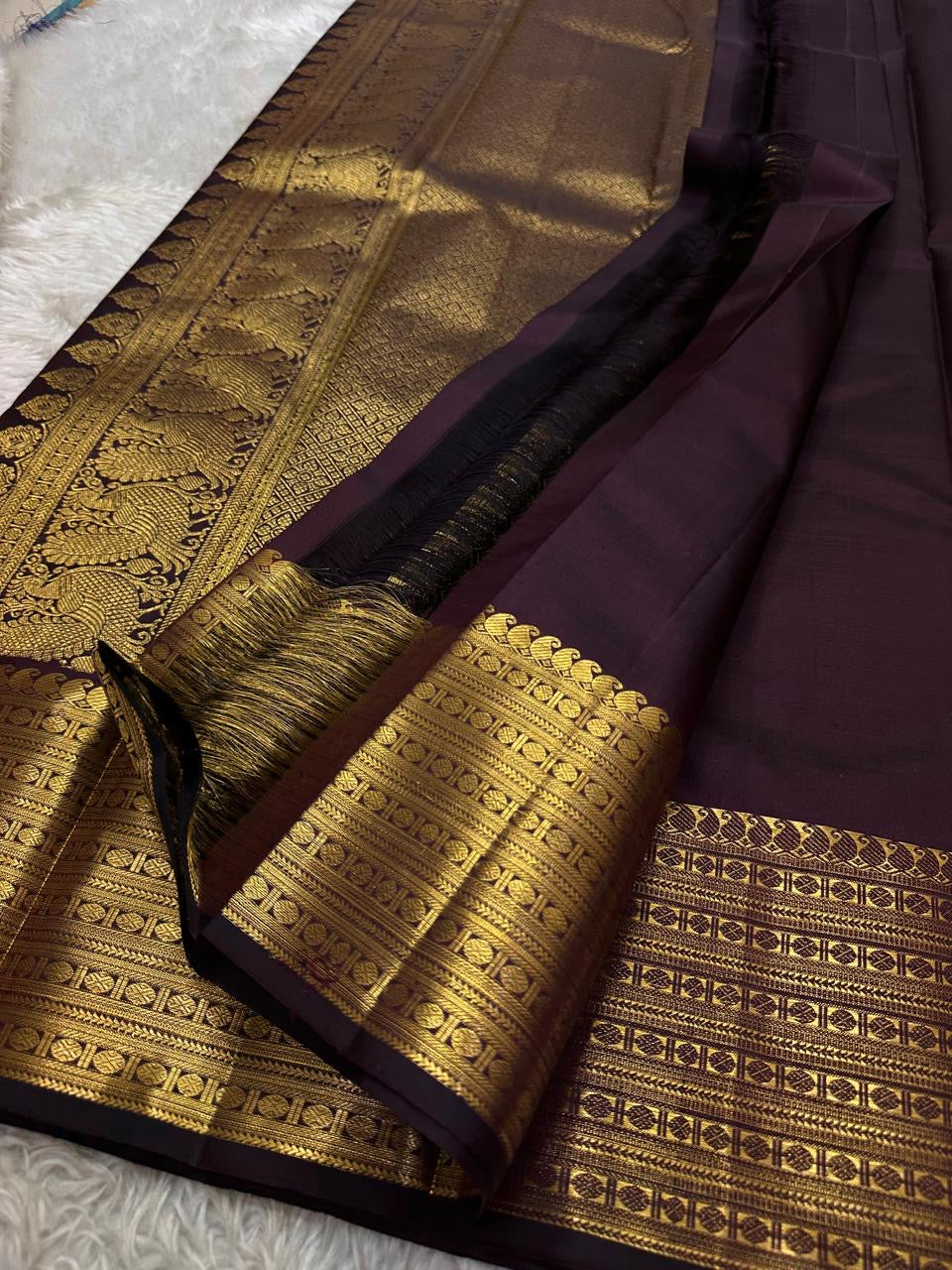Cholai – Orchard at Dusk ✨ A pure Kanchipuram silk in deep purplish-brown, adorned with regal Gandaberunda 🦅 and delicate Kamalam 🌸 motifs. Its gold zari border layers Varisaipet, mango paisley 🥭, Rudhraksham, and Vanki for a true heritage masterpiece