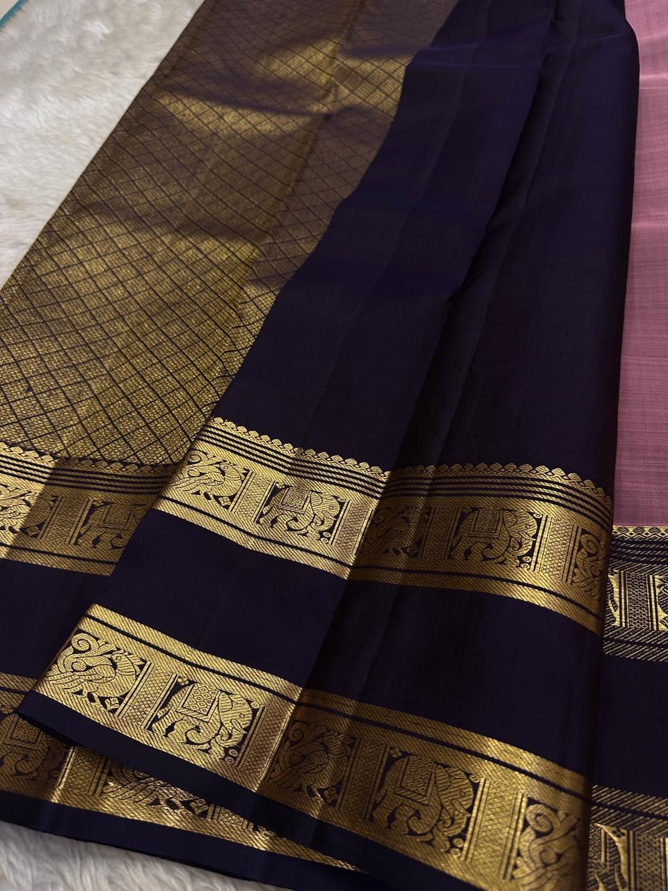 Midnight Blue & Mauve — Pure Silk Kanchipuram
Mauve body with pin-stripes & zari coin buttas ✨
Midnight-navy korvai borders with gaja panels 🌸
Grand navy brocade pallu with tassels 🪔
Silk Mark Certified • Free Shipping USA • Ships in Two Weeks ✅