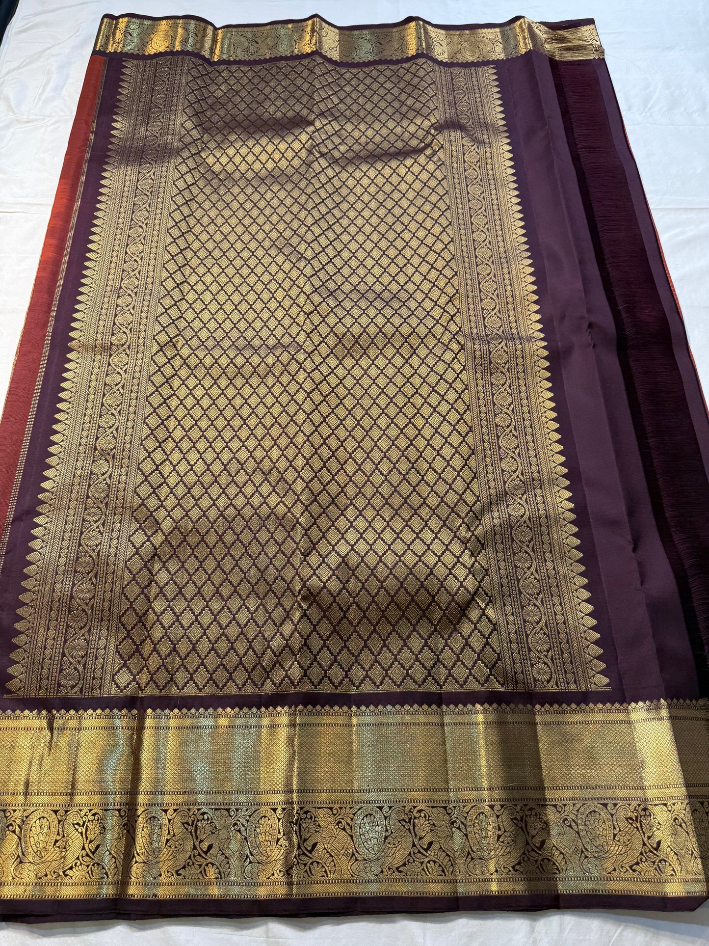 Rust Orange Kattam & Purple Korvai – Pure Kanchipuram Silk Saree
Rust-orange checks with delicate gold buttas and contrast purple korvai borders
Grand purple zari-pallu | Contrast purple blouse | Fall & Pico Done
Silk mark certified ships