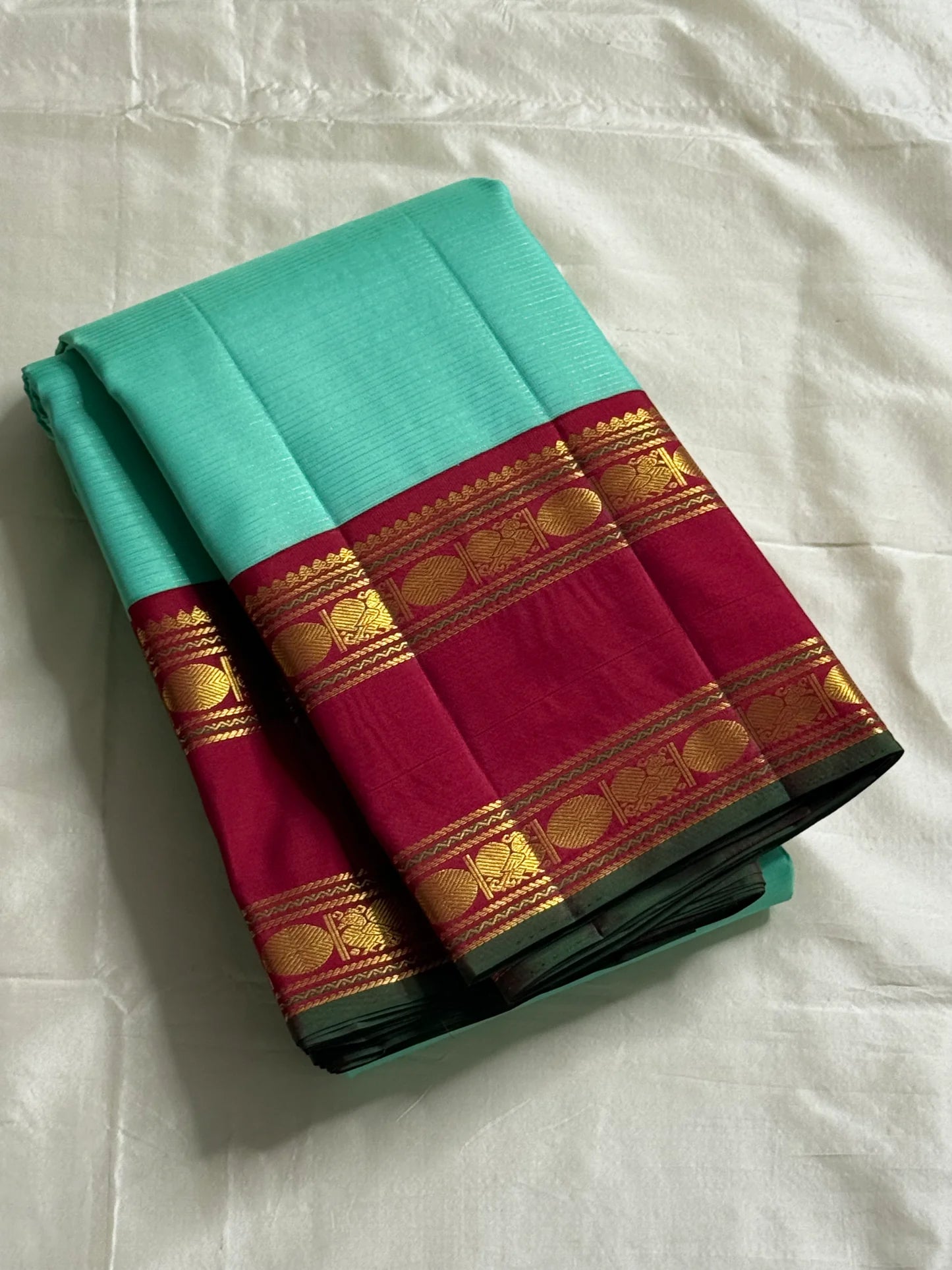 Neer Pachai Vairaoosi — Kanchipuram Pure Silk saree 
Sea-foam/aqua body with classic Vairaoosi pinstripes
Contrast ruby-maroon korvai borders with gold chakram & floral panels
Grand maroon pallu with all-over chakram jaal and paisley vines; aqua tassel