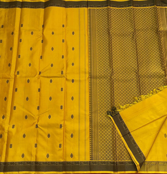 Marigold – Pure Kanchipuram Silk Saree
Haldi yellow body with charcoal paisley buttas
Contrast charcoal border in silk thread, floral vine
Silk Mark Certified | Blouse Piece Included | Fall & Pico Done
Free Shipping within USA | Ships in 2 Weeks