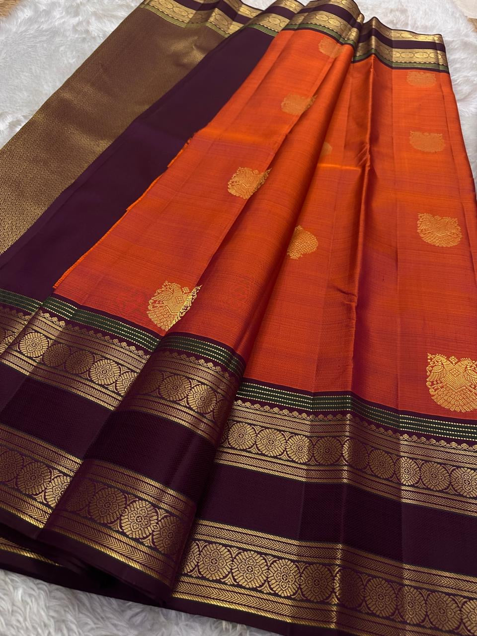 Ishwaryam 🧡❤️🕊️✨
Orange Red Shot Handwoven Kanchipuram Silk Saree with Majestic Gandaberunda Zari Adai Motif 🕊️🌟
Ornate Rettapet Border with Delicate Kamalam Seer Floral Detailing 🌺🪡
Deep Coffee Brown Pallu Adding Warmth and Elegant Contrast ☕🌿