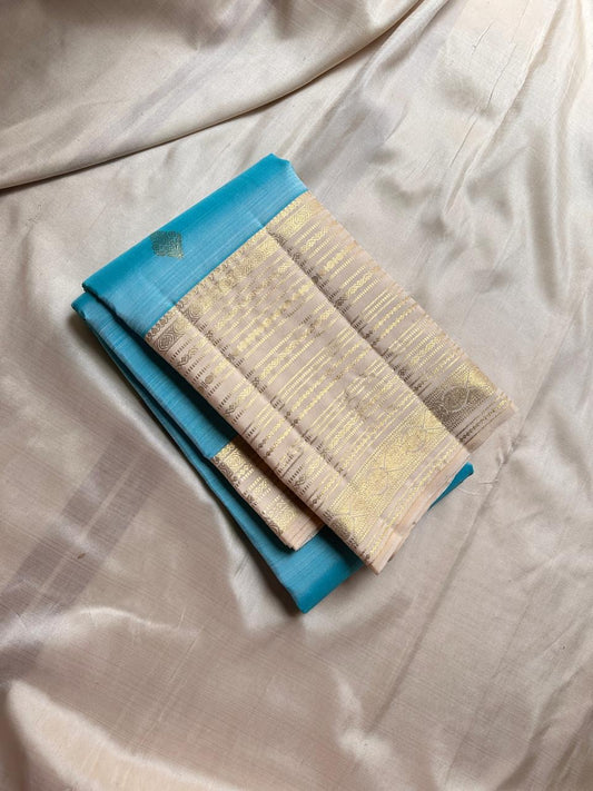 Blue Vennila Varisai – Pure Kanchipuram Silk Saree
Blue body with gold leaf buttas; contrast ivory varisai borders
Grand ivory pallu with rich zari stripes; contrast ivory blouse
Silk Mark Certified | Blouse Piece Included | Fall & Pico Done
Free Shipping
