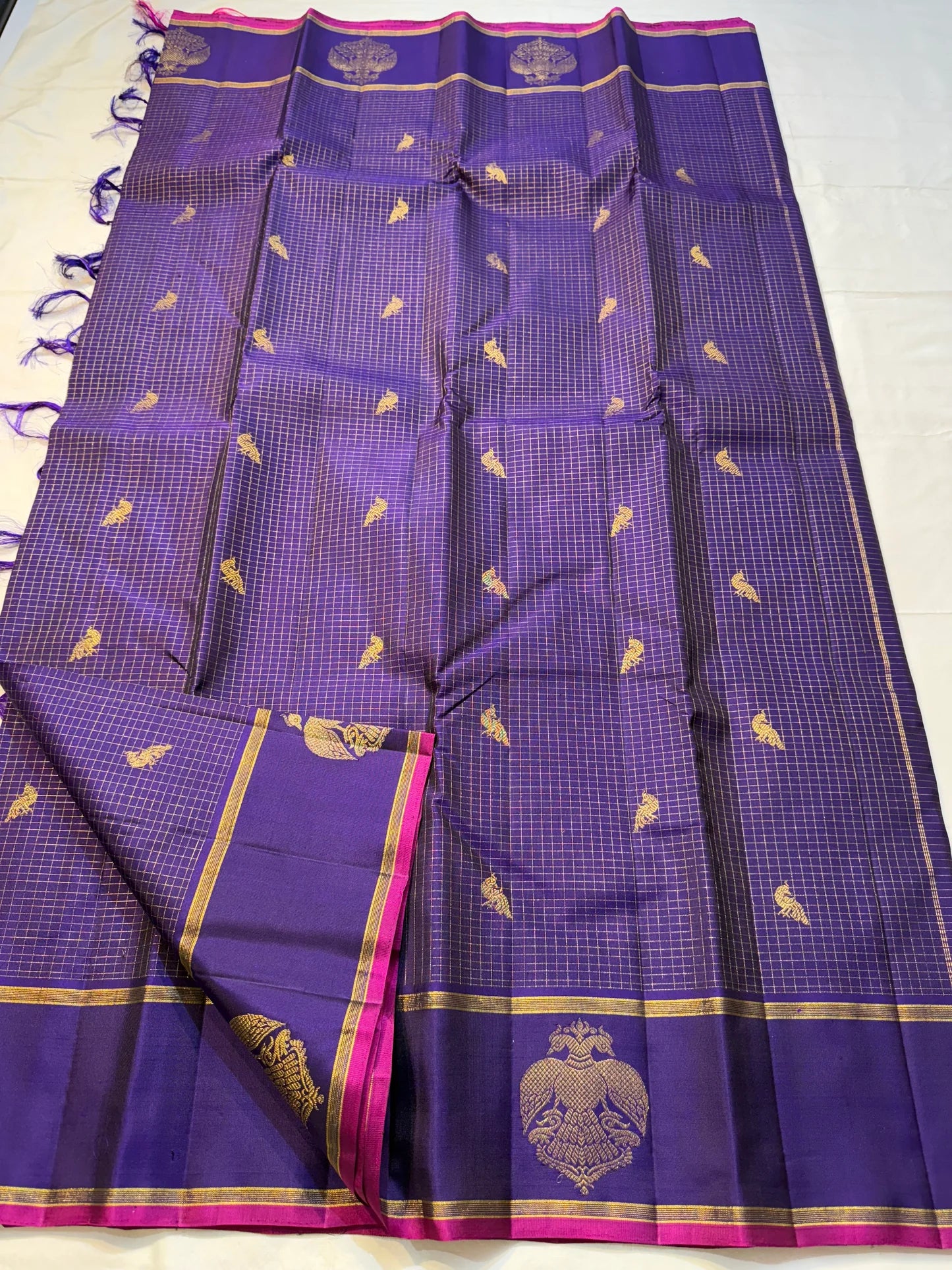 Vadamalli Gandaberunda Kattam — Pure Silk Kanchipuram Saree
Royal purple body with fine kattam checks & zari mankolam buttas, adorned with grand Gandaberunda borders and rich diamond brocade pallu with pink selvedge.
Silk Mark Certified ✅ | Fall & Pico
