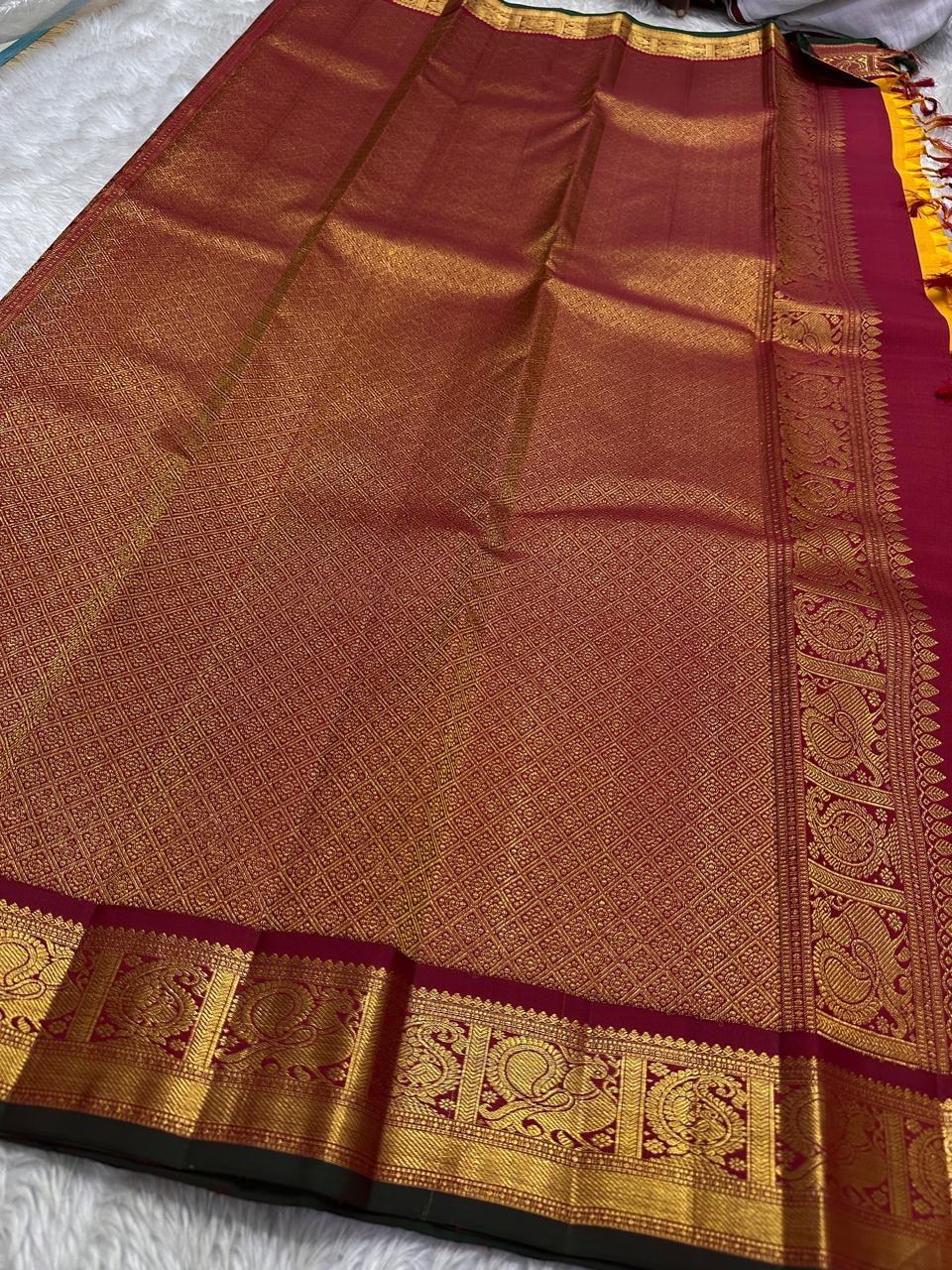 Saffron Royale – Pure Kanchipuram Silk Saree with Peacock Motif Border
Majestic saffron body with delicate zari buttas.
Rich maroon border woven with grand peacock motifs in zari.
Traditional maroon pallu. Silk Mark Certified, delivery in 2 weeks