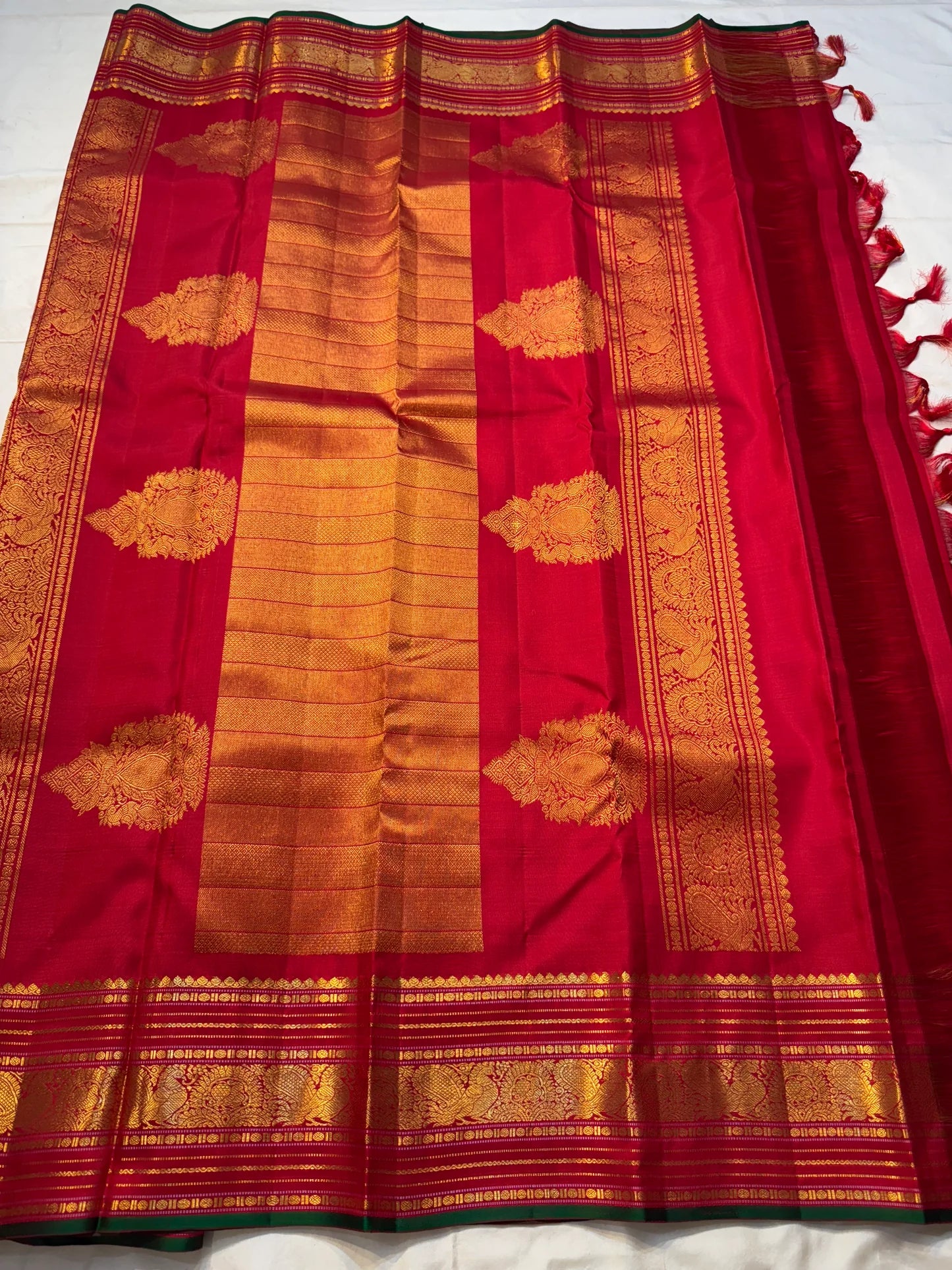 Ravi Kiranam — Sona Roopa Kattam Kanchipuram Pure Silk
Vibrant festive red body with allover kattam (grid) checks
Gold & silver sona-roopa zari alternating for a soft shimmer
Grand kaddi border with rich zari paisley vines & floral tracery
Silk Mark