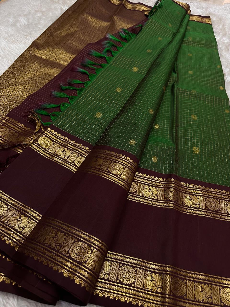 Geetham ✨
Forest Green Zari Kattam Pure Silk Kanchipuram Saree 🌿
With Ornate Rettapet Border of Peacock & Kamalam Motifs 🦚🌸
Flanked by Muthuseer Florals & Vanki Neli Columns 🌺
Finished with a Grand Brocade Maroon Pallu in Rich Zari ✨