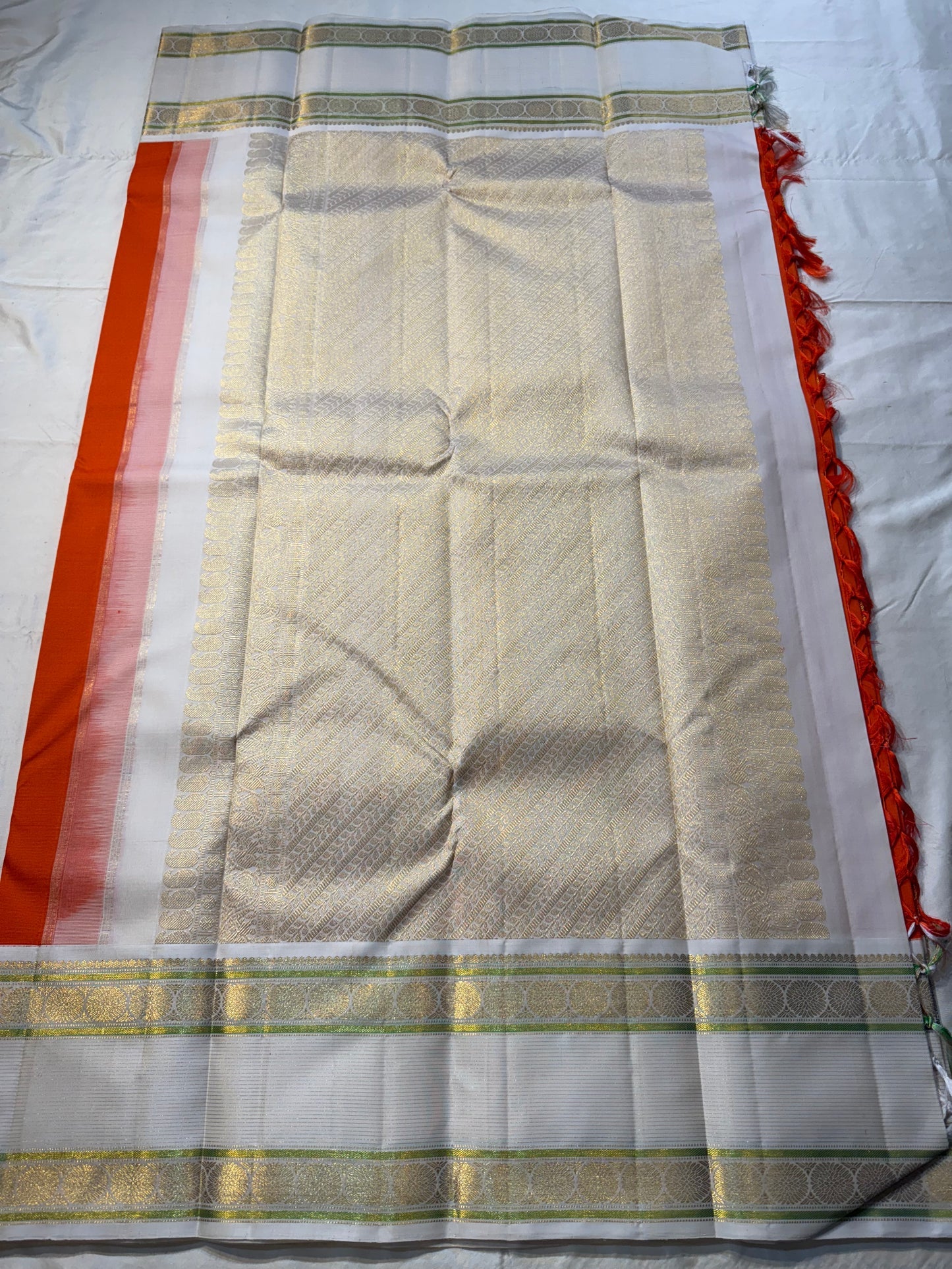 Kesar Chakram – Pure Kanchipuram Silk Saree
Rich Kesar Orange Body with Golden Chakram Buttas
Ivory Korvai Borders with Zari Rosette Motifs & Green Selvedge
Grand Ivory-Gold Brocade Pallu with Orange Tassels
Silk Mark Certified | ships in 2 weeks