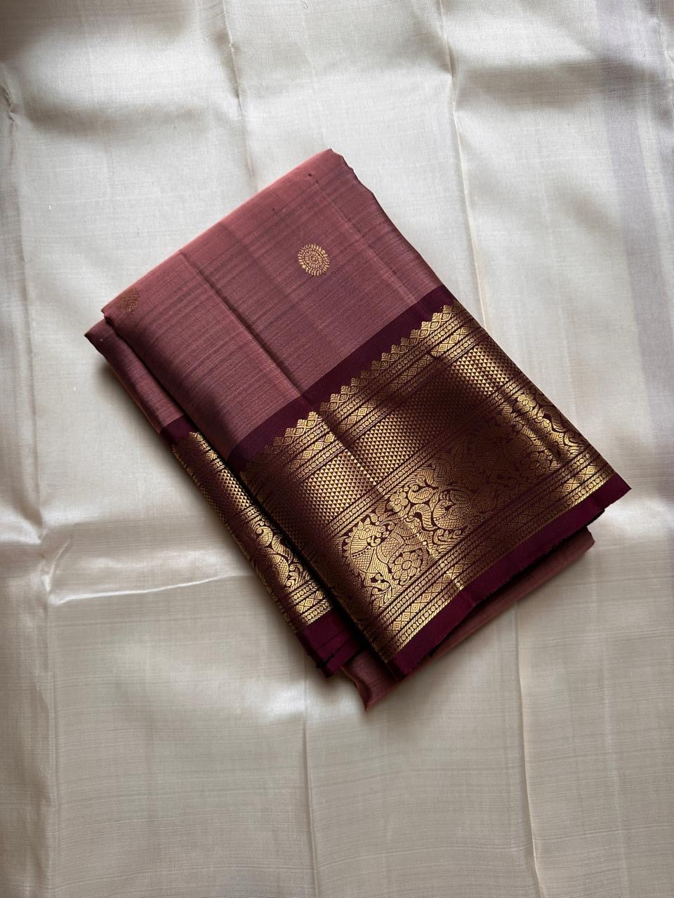 Mauve Buttas – Pure Kanchipuram Silk Saree
Ethereal mauve body adorned with buttas ✨
Borders rich in regal zari with floral and animal artistry 🌿🦚
Grand pallu woven in opulent gold jaal, exuding heritage charm 💫 Silk Mark Certified, delivery in 2 weeks