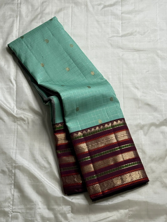 Teal Mint Muthu Kattam — Pure Silk Kanchipuram Saree
Teal-mint body with tiny  zari  buttas & plum-maroon korvai borders
Silk Mark Certified • Free USA Shipping • Ships in Two Weeks