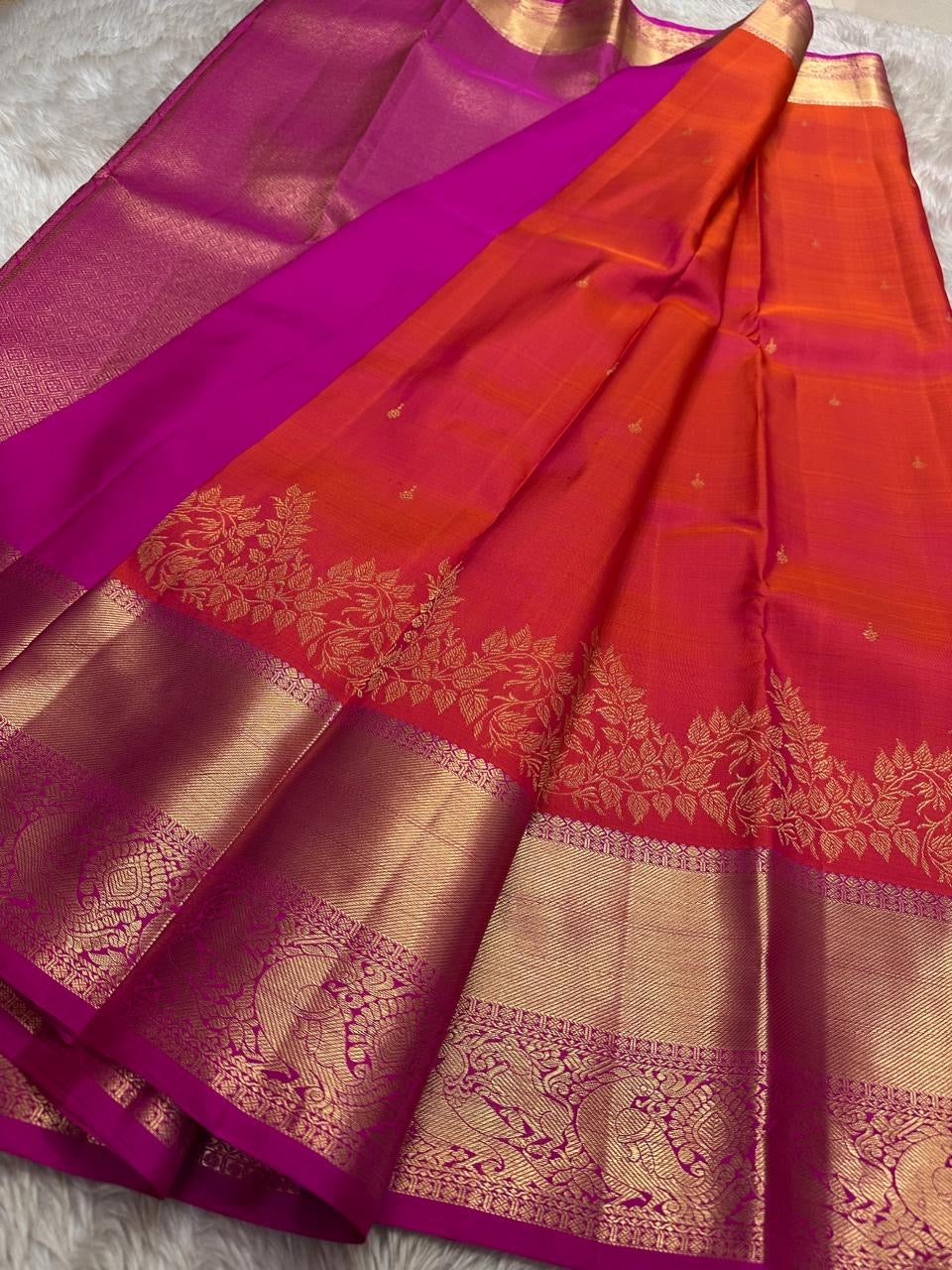 Sunset Peacock – Pure Kanchipuram Silk Saree
Sunset-Orange to Fuchsia Body with Zari Buttas ✨
Gold Zari Peacock Panel Border with Leafy Creeper Motif
Grand Fuchsia Brocade Pallu with Lattice Jaal Weave
Silk Mark Certified, delivery in 2 weeks