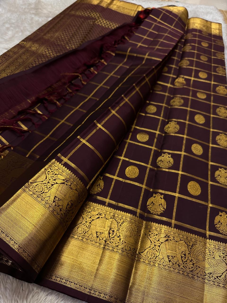 Ambaram – Coffee Brown
 — Pure Kanchipuram Silk
Elephant & Peacock Procession Zari Border • Coin & Gandaberunda Buttas
Geometric Diamond Brocade Pallu in Antique Gold
Handloom •
Silk Mark Certified • Ships in Two Weeks