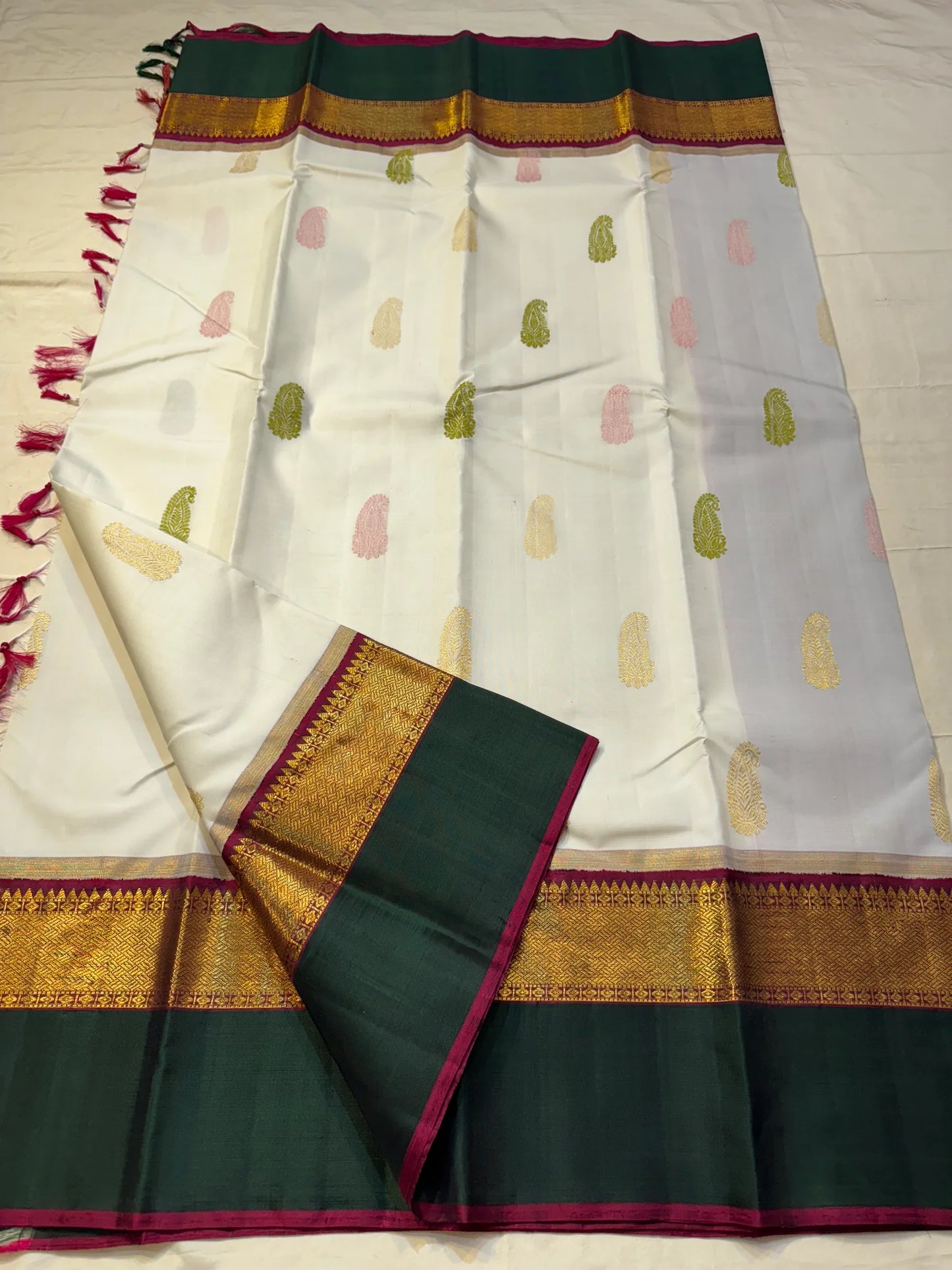 Ivory Malligai — Pure Silk Kanchipuram Saree
Ivory body with multi-color paisley buttas and gold zari diamond border
Arakku pallu with floral zari weave | Silk Mark Certified | Ships in Two Weeks | Free USA