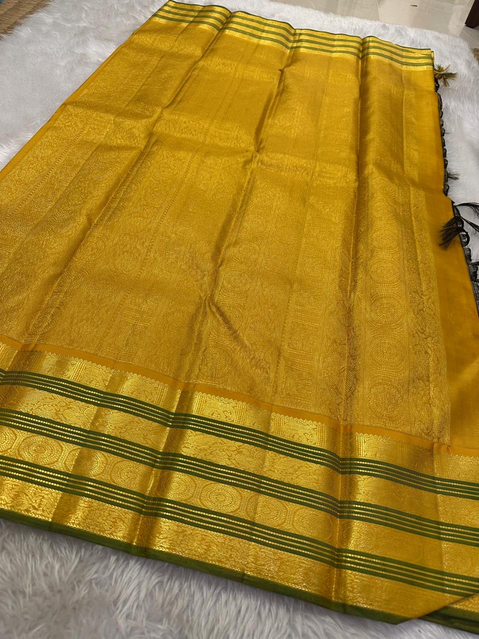 Adar Manjal Chakram – Pure Kanchipuram Silk Saree
Deep green & Manjal-Gold Zari Korvai Borders
Chakram & Floral Zari Motifs, Grand Manjal Brocade Pallu
Silk Mark | Fall & Pico Done | Blouse Stitching Available | ships in 2 weeks