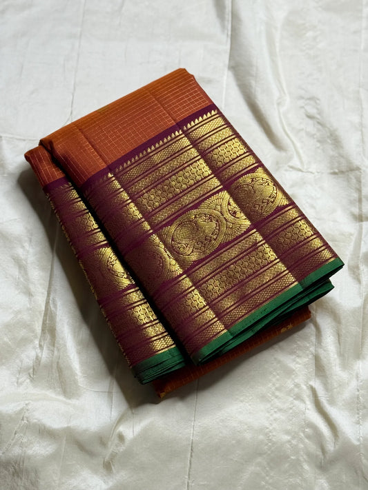 Rust Orange Pakshi Kattam – Pure Korvai Kanchipuram Silk Saree
Rust-orange micro-checked body with zari rosette & mango buttas
Plum korvai border with pakshi medallions & emerald selvedge; ships in two w
Silk Mark Certified | blouse Stitching available