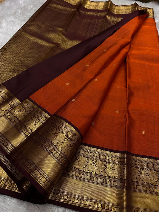 Rust Annam Butta — Kanchipuram Pure Silk
Rust-orange (semman/rust) body with zari chakram buttas
Deep maroon korvai borders with annam (swan) vine motifs
Lavish maroon-gold zari pallu with temple serrations
Silk Mark Certified | Free Shipping