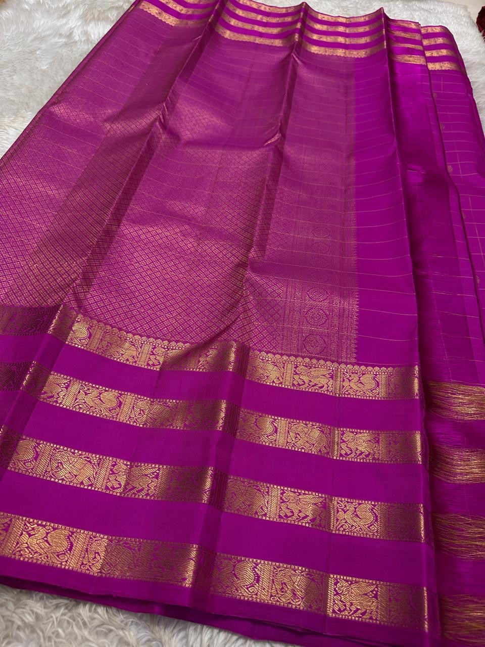 vasantham Fuchsia pink – Handwoven Kanchipuram Silk Saree A poem in Fuchsia silk. The body glows in a serene vibrant Fuchsia, softly accented by delicate gold vertical lines and dainty gold zari buttas that glint like little blessings.