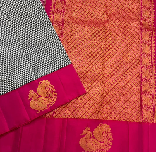 Aaradhana Kattam — Pure Kanchipuram Silk Saree (Black & White × Rani Pink)
Classic black-and-white micro checks with rich rani-pink korvai borders and zari peacock motifs
Silk Mark Certified • Fall & Pico Done • Blouse Stitching Available ($30) • Free Shi