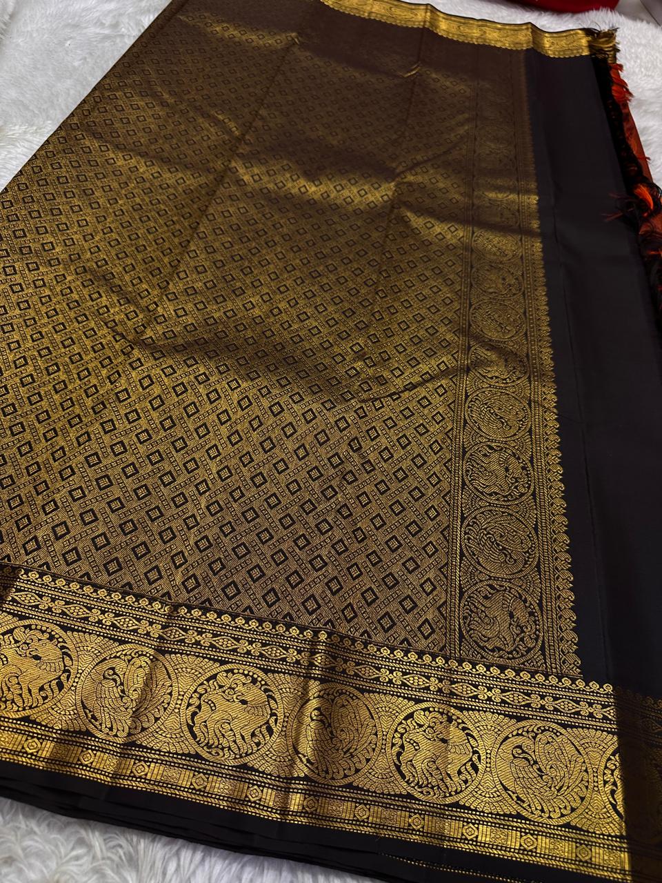 Rust Simha – Pure Silk Kanchipuram Saree
Rust Orange Body with Petite Gold Floral Buttas
Black Korvai Contrast Border with Simha & Annapakshi
Grand Zari Pallu
Comes with Contrast Black Blouse Piece with Zari Border silk Mark certified, ships in 2 weeks