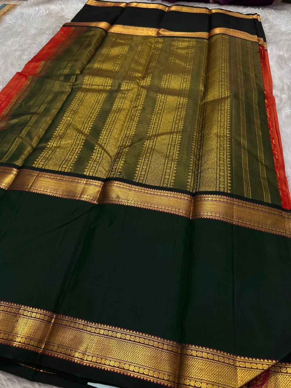 A festive radiant orange silk saree with a rich vairaoosi all over bottle green border, woven to celebrate tradition with a bold flair.