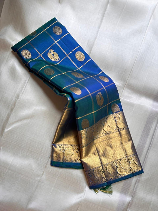 Nemali Zari Checks | Pure Silk Kanchipuram
Peacock-Blue & Emerald-Green Dual Tone • Zari Checks with Buttas
Gold Zari Borders with Paisley Motifs • Rich Brocade Pallu
Silk Mark Certified • Free Shipping within USA
Ships in Two Weeks | Blouse Sti