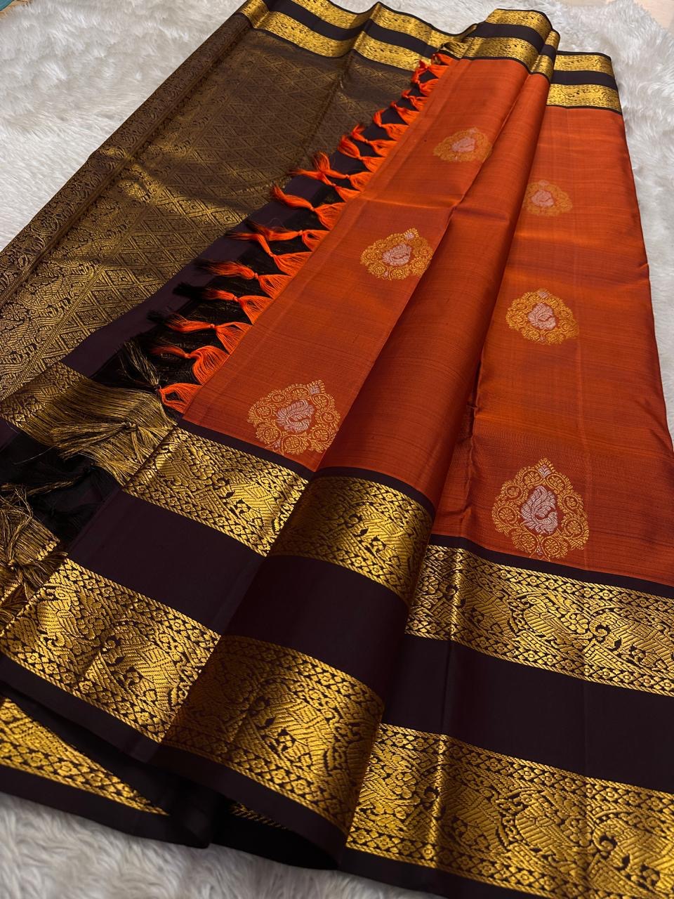 The Rust Orange Abharna: A Silk Mark Certified Kanchipuram Pure Silk Saree
with Maroon and Gold Elephant Zari Border & Rich Zari Pallu
Handwoven with Exquisite Peacock Motifs
Free Shipping within USA on this Handloom Creation
Ships in 1 Week