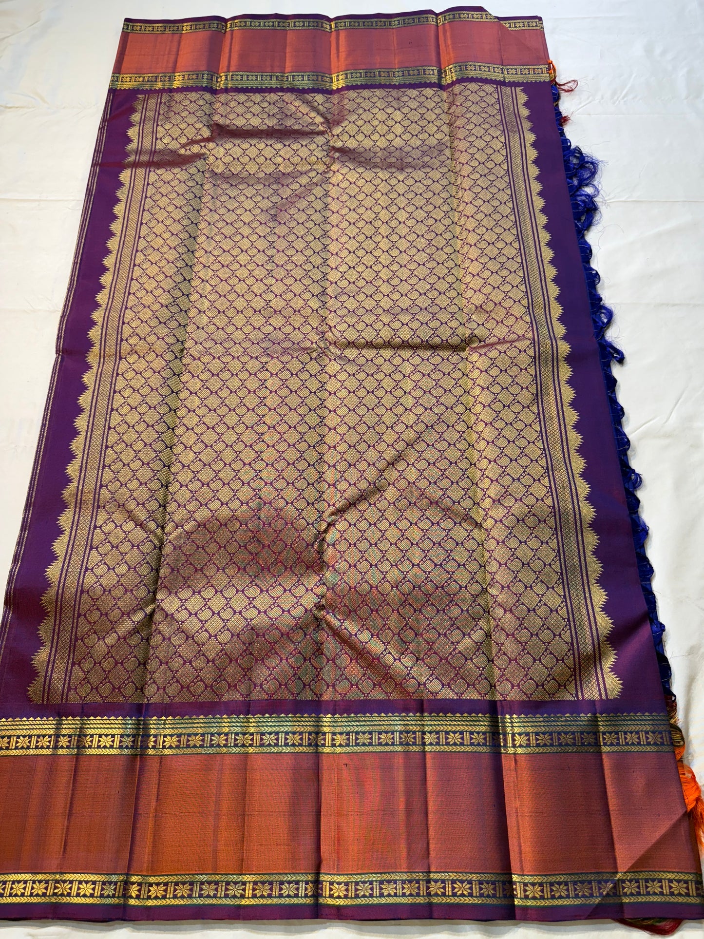Indra Neelam Kattam – Pure Kanchipuram Silk Saree
Royal Blue Body with Fine Zari Grid Checks
Copper-Rose Korvai Borders with Floral & Chevron Zari
Grand Purple Pallu with Tassels
Silk Mark Certified | ships in 2 weeks | Blouse Stitching Available