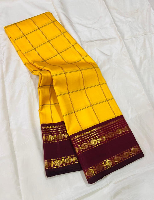 Marigold Yellow & Arakku Pure Silk Kanchipuram Saree
Classic kattam checks across the radiant marigold body
Deep arakku-maroon korvai borders with coin medallion zari
Rich maroon pallu with traditional zari  motifs
Silk Mark Cert • Ships in 2 weeks