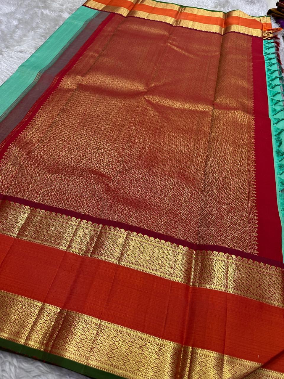 Poomugam Pachai
Pure Silk in Tender Mint & Kumkum Red
Zari-Woven Grandeur in korvai Contrast