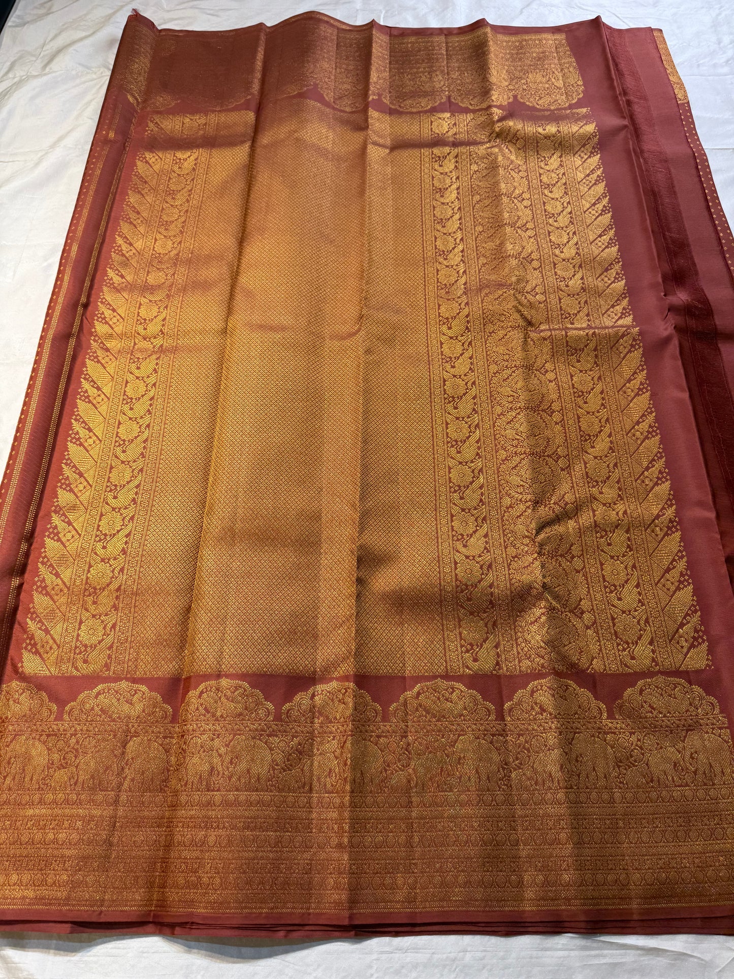 Rust Orange Elephant Peacock Arches – Pure Silk Kanchipuram Saree
Tiny gold podi butta motifs with grand elephant & peacock arch borders
Rich antique-gold zari pallu with floral columns & temple designs
Silk Mark Certified | Free Shipping within USA-