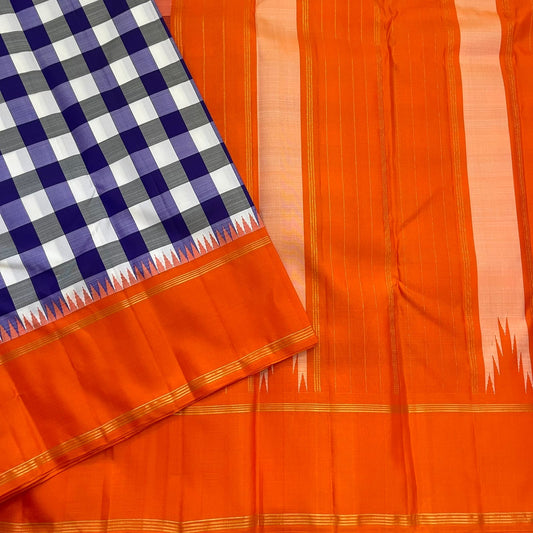 Indigo–Tangerine Checkmate — Pure Silk Kanchipuram
Bold indigo–lilac–white buffalo checks with ash accents ✨
Vibrant tangerine korvai border with temple (reku) teeth 🌸
Solid tangerine pallu with fine thread stripes & tassels 🪔
Silk Mark Certified •