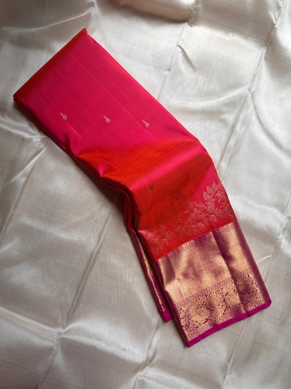 Sunset Peacock – Pure Kanchipuram Silk Saree
Sunset-Orange to Fuchsia Body with Zari Buttas ✨
Gold Zari Peacock Panel Border with Leafy Creeper Motif
Grand Fuchsia Brocade Pallu with Lattice Jaal Weave
Silk Mark Certified, delivery in 2 weeks
