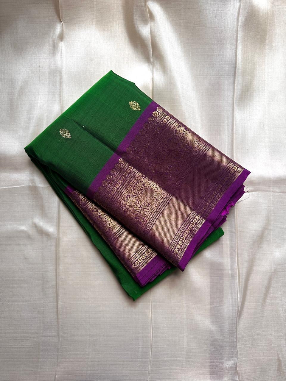 Green Amethyst Grove — Pure Silk Kanchipuram Saree
Emerald-Green Body with Gold Buttas & Royal-Purple Elephant Zari Border ✨
Silk Mark Certified • Free USA Shipping • ships in 2 weeks