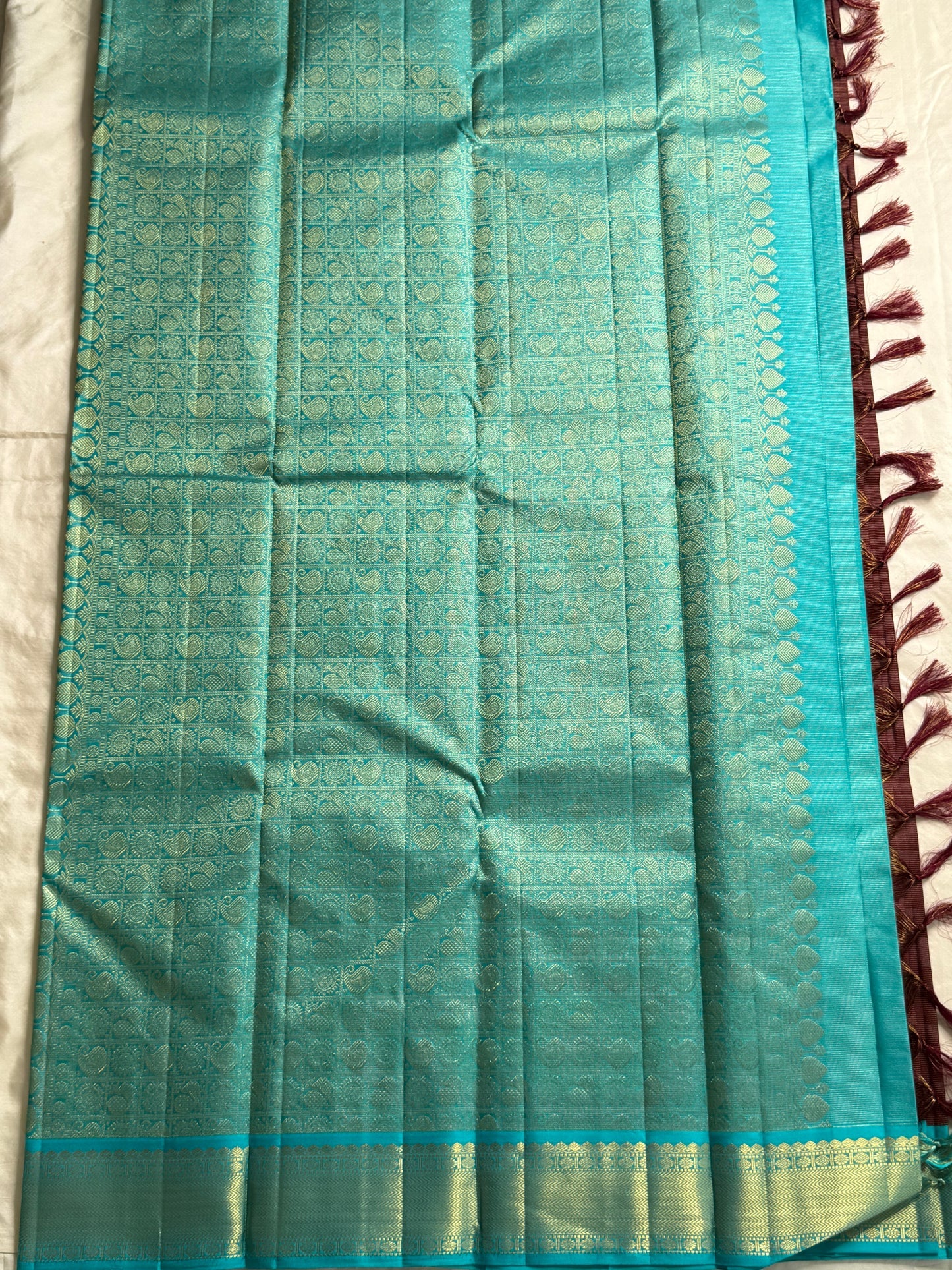Rathi – Earthy Brown Vairaoosi Silk Saree with Petite Kamalam & Chakram Buttas, featuring a finely Woven Muthu Seer Zari Border in a Classic Style
Pallu in Soothing Rama Blue with Grid-Like Zari Motifs of Paisley & Chakram