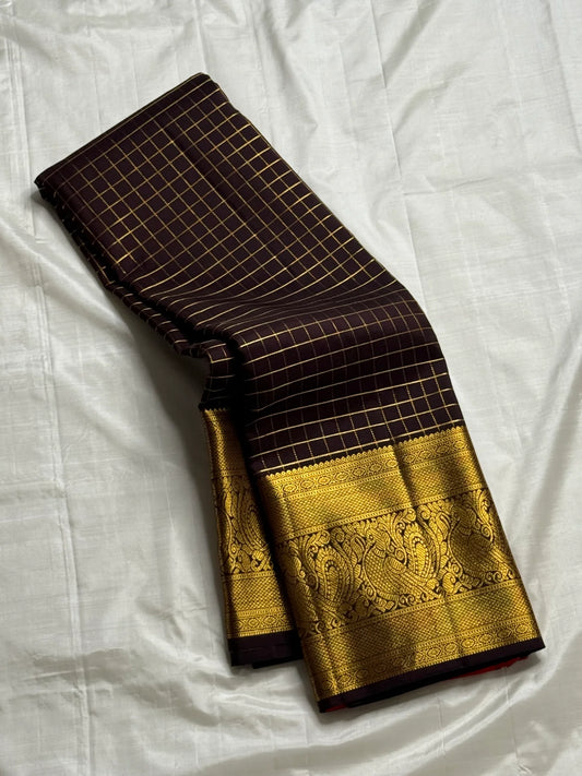 Mathura Layam — Pure Silk Kanchipuram Saree
Deep espresso brown with gold varisaipet checks & peacock zari border
Vermilion red vaira-kattam pallu | Silk Mark Certified | Ships in 2 Weeks | Free USA Shipping