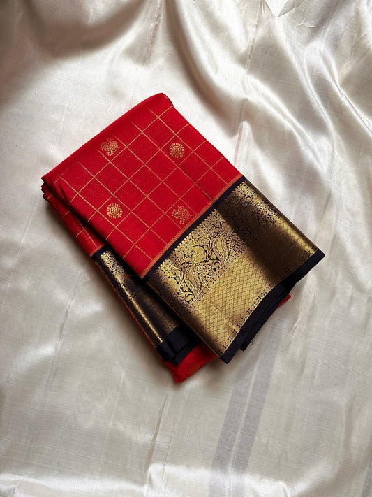 Vermilion red meets classic black. Fine kattam checks with coin buttas, peacock-zari borders and a regal black brocade pallu—made for Diwali lights, vows, and heirloom moments. Silk Mark Certified • Dispatch in 1 week • Free USA Shipping