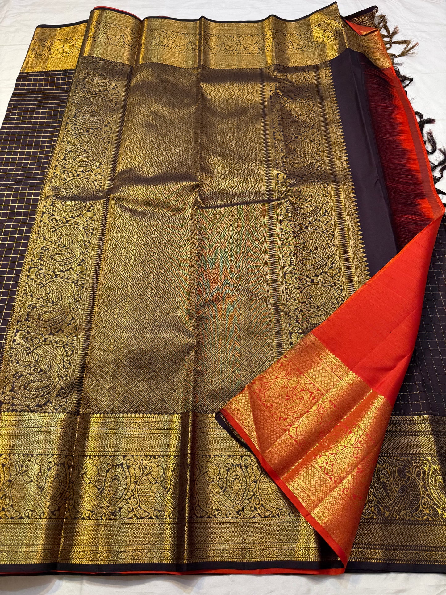 Mathura Layam — Pure Silk Kanchipuram Saree
Deep espresso brown with gold varisaipet checks & peacock zari border
Vermilion red vaira-kattam pallu | Silk Mark Certified | Ships in 2 Weeks | Free USA Shipping