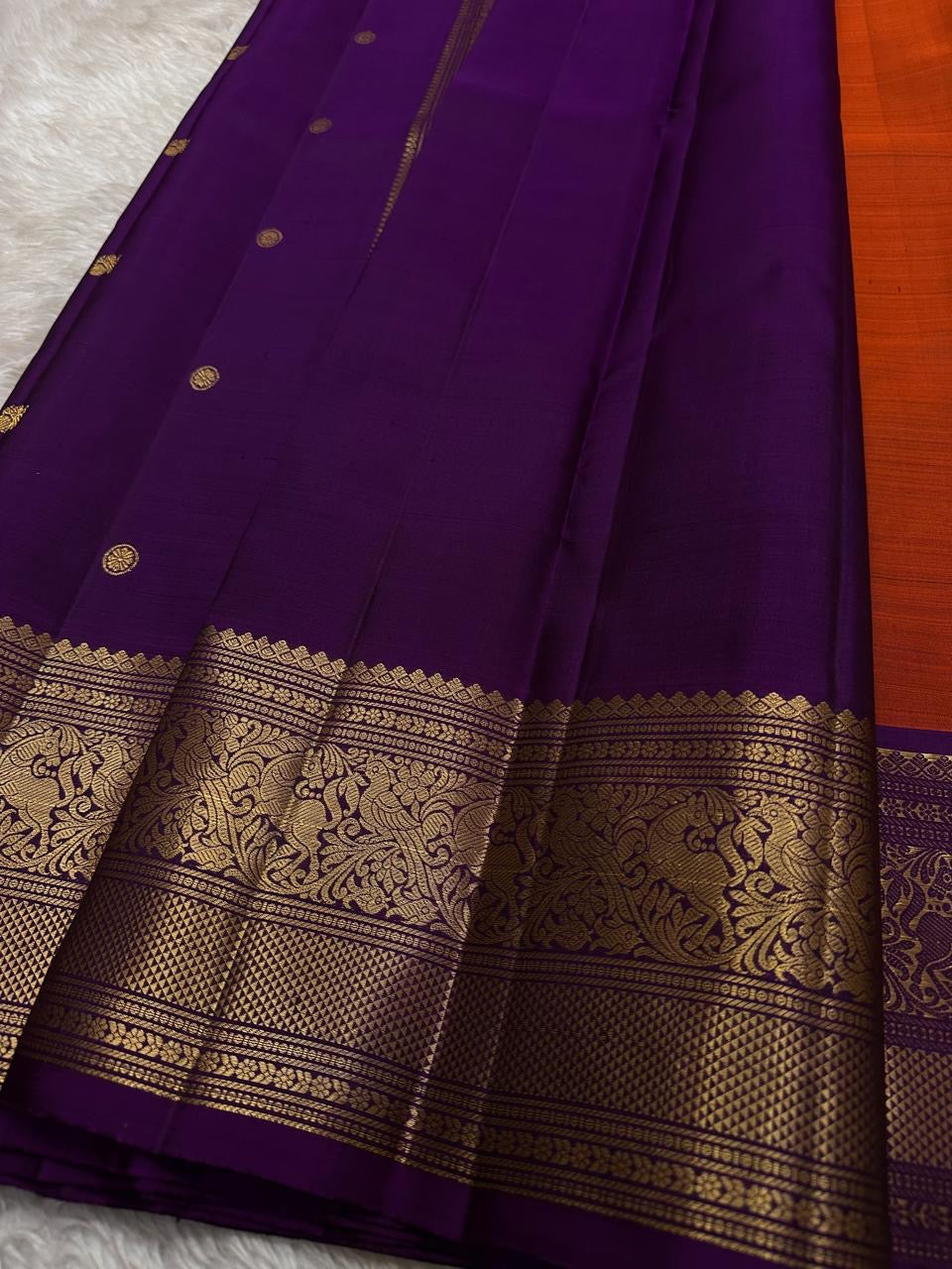 Sindhoora Valli – Orange & Violet Kanchipuram Pure Silk Saree ✨
Auspicious Orange Body with Golden Zari peacock Buttas
Violet Korvai Border with Temple-Inspired Motifs
Grand Violet Pallu with Intricate Zari Weaving
Silk Mark Certified, delivery in 2 week